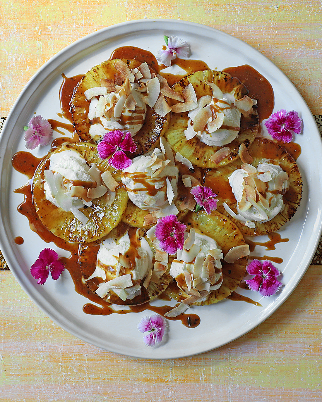 Carpaccio de piña tostada con Salsa Toffee Trufado y escamas de coco